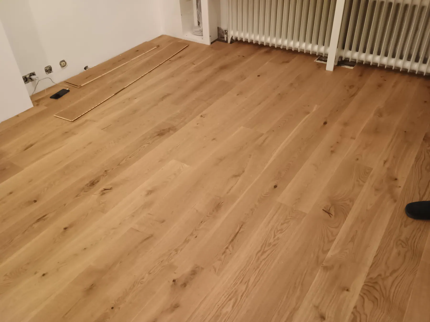 Verlegter Parkettboden im Wohnraum mit Heizkörper